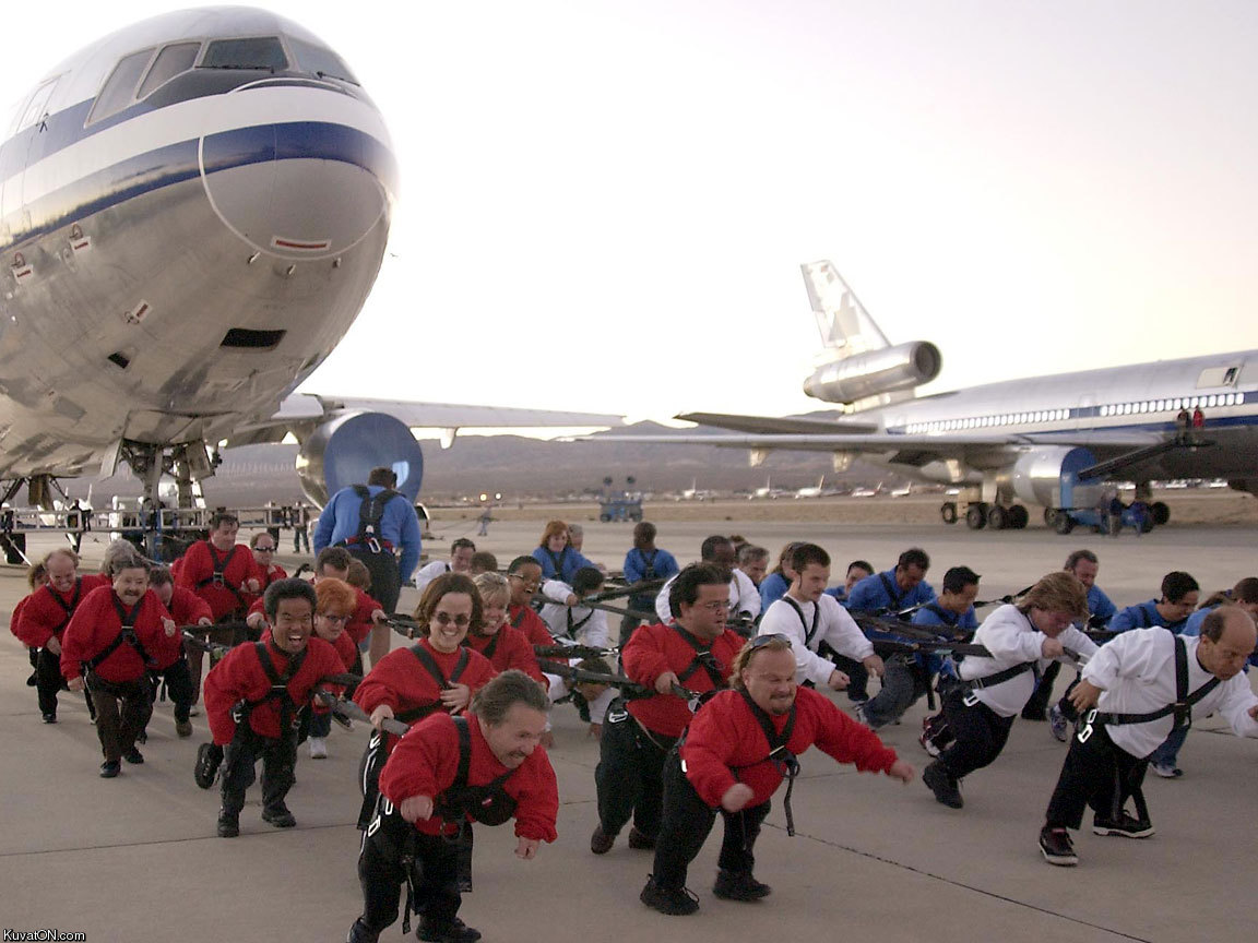 bunch_of_midgets_pulling_airplane.jpg