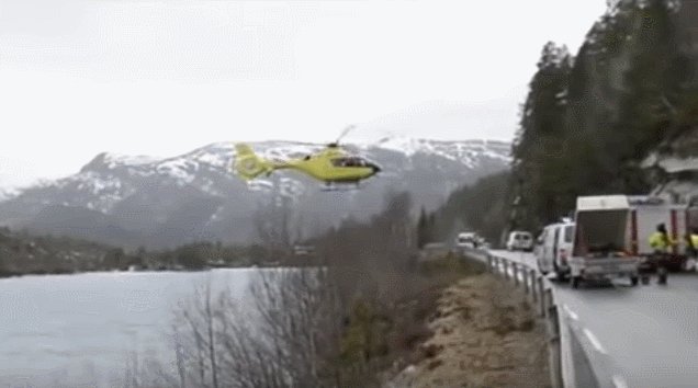 helicopter_balances_on_road_railing_to_let_off_doctor.gif